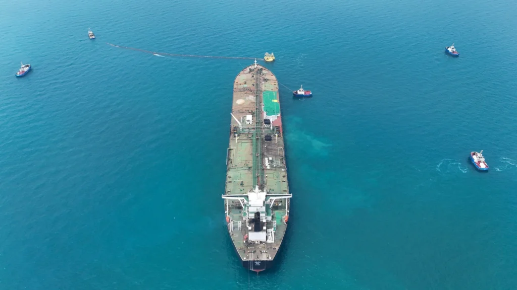 Hürmüz Boğazı'nda Tansiyon Zirvede: Tankerlere Yönelik Saldırılarda Savaşın Başından Bu Yana En Yüksek Seviye Deniz güvenliği kaynaklarına göre, Hürmüz Boğazı'ndan geçen ticari tankerlere yönelik saldırılar geçtiğimiz hafta, İran savaşının başladığı günden bu yana görülen en yüksek seviyeye ulaştı. ABD Donanması öncülüğündeki Ortak Deniz Bilgi Merkezi (JMIC) pazar günü yayımladığı bilgi notunda; İran Devrim Muhafızları tarafından gerçekleştirilen drone uçuşları, gözetleme faaliyetleri ve telsiz (VHF) anonsları gibi taciz eylemlerinin yanı sıra fiili saldırı ve saldırı girişimlerinin boğazda kesintisiz devam ettiğini bildirdi. JMIC açıklamasında, "Bu eylemler, İran'ın kilit geçiş güzergahlarında varlık gösterme ve transit gemiler üzerindeki baskıyı sürdürme niyetini ortaya koymaya devam ediyor," ifadelerine yer verildi. Bir Haftada 12 Saldırı Kaydedildi Bölgeden alınan verileri analiz eden üç farklı deniz güvenliği kaynağına göre, 28 Eylül - 5 Ekim haftasında Hürmüz Boğazı çevresinde petrol, sıvılaştırılmış doğalgaz (LNG) ve sıvılaştırılmış petrol gazı (LPG) taşıyan tankerlere yönelik en az 12 saldırı düzenlendi. Kaynaklar, bu rakamın ABD ile İran arasındaki savaşın başladığı 28 Şubat'tan bu yana tek bir haftada kaydedilen en yüksek saldırı sayısı olduğunun altını çizdi. Birleşmiş Milletler'e (BM) bağlı Uluslararası Denizcilik Örgütü'nün (IMO) derlediği ayrı veriler ise aynı hafta içinde gemileri hedef alan 9 olay yaşandığını ortaya koydu. Denizcilik uzmanları, BM kurumunun olayları doğrulama ve resmi olarak kayıt altına alma sürecinin daha uzun sürdüğüne dikkat çekiyor. IMO verilerine göre, bu yoğunluğa en yakın rakam 8 olayın rapor edildiği 13 Temmuz haftasında kaydedilmişti. Mürettebat Yaralandı, İhracat Beklentileri Gölgelendi Pazartesi günü yayımlanan denizcilik verileri, Körfez bölgesi petrol ihracatçılarının eylül ayının ilk yarısında savaş öncesi seviyeleri aştığını gösterse de, artan tanker saldırıları ve lojistik darboğazlar yüksek ihracat akışının sürdürülebilirliğine dair beklentileri gölgeliyor. Bölgedeki güvenlik riskinin somut bir örneği olarak Hindistan Dışişleri Bakanlığı, salı günü yaptığı açıklamada Panama bandıralı petrol tankeri "On Peace"in Hürmüz Boğazı'ndan geçişi sırasında kaynağı belirsiz bir mühimmatın hedefi olduğunu duyurdu. Saldırıda gemide bulunan 12 mürettebatın yaralandığı bildirildi.